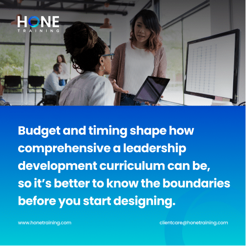 Two women collaborate in a bright office space with a laptop and a large monitor; overlay text presents a quote about budget and timing shaping leadership development design, and a HONETRAINING logo is visible in the corner.