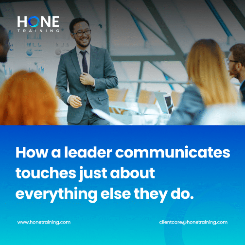 Presenter in a suit speaks to colleagues in a modern office; blue banner shows the title 'How a leader communicates touches just about everything else they do.' and the HONE Training logo.